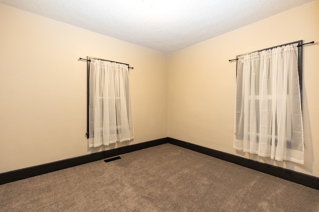 carpeted spare room featuring a textured ceiling