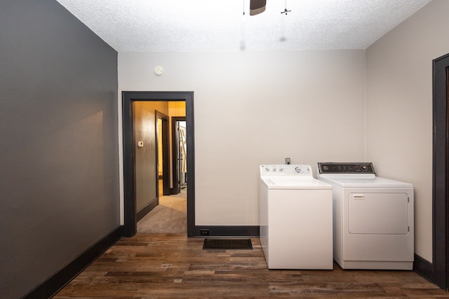 clothes washing area with dark hardwood / wood-style flooring, ceiling fan, washing machine and clothes dryer, and a textured ceiling