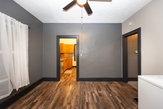 unfurnished room featuring dark wood-type flooring, ceiling fan, and a textured ceiling