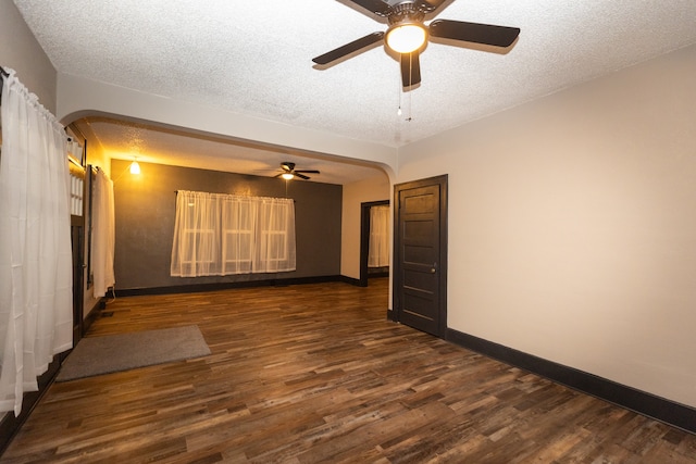 empty room featuring ceiling fan, dark hardwood / wood-style flooring, and a textured ceiling