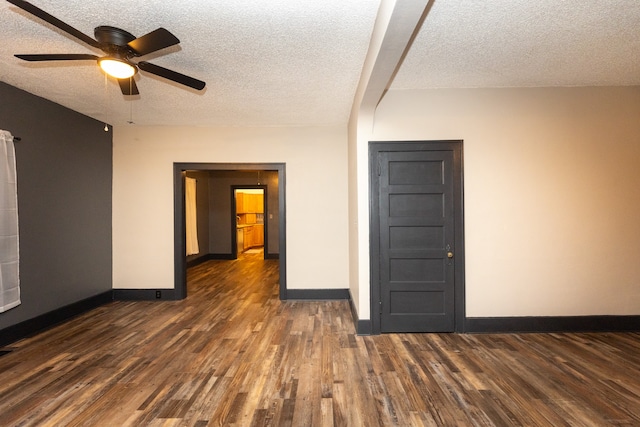 empty room featuring dark wood-type flooring, a textured ceiling, and ceiling fan