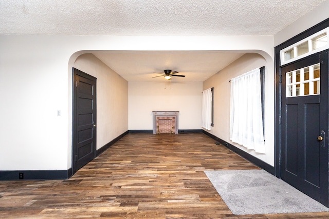 foyer with ceiling fan, dark hardwood / wood-style floors, and a textured ceiling