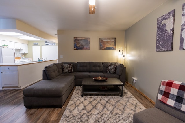 living room featuring ceiling fan and dark hardwood / wood-style floors