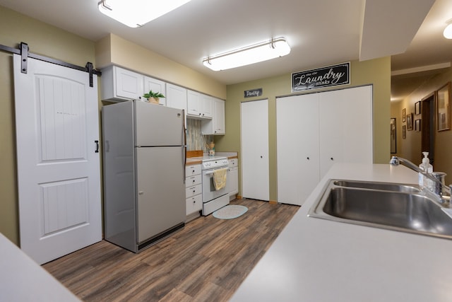 kitchen featuring white cabinetry, white appliances, sink, dark hardwood / wood-style floors, and a barn door