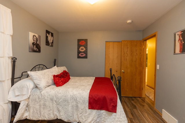 bedroom with dark wood-type flooring and a closet