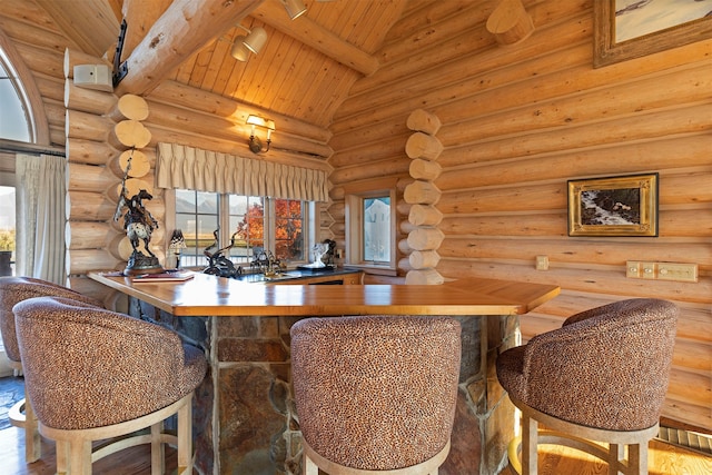 bar with beam ceiling, wood ceiling, rustic walls, and wood-type flooring