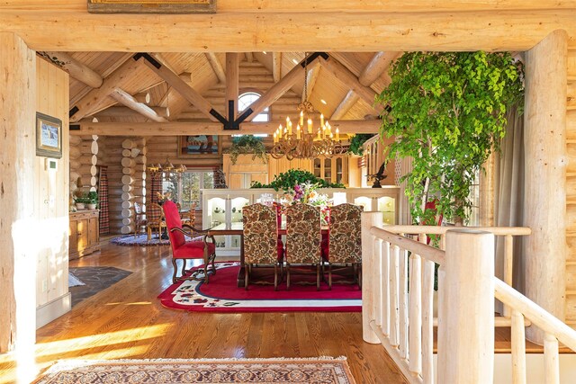 dining area with a chandelier, log walls, vaulted ceiling with beams, and dark hardwood / wood-style flooring