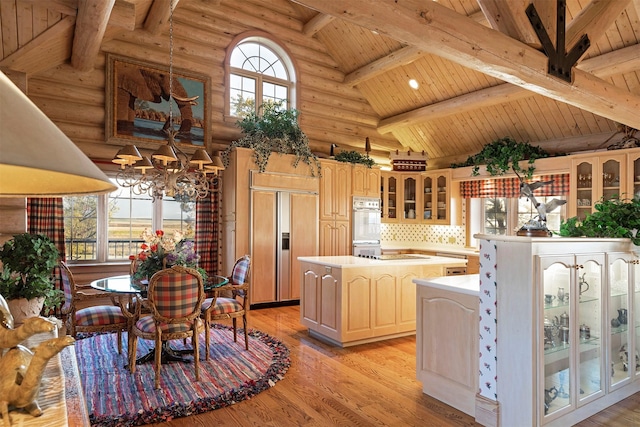 55263 Logan Rd, Charlo, MT 59824 - kitchen with paneled fridge, wood ceiling with exposed beams, high vaulted ceiling, light countertops, and a center island