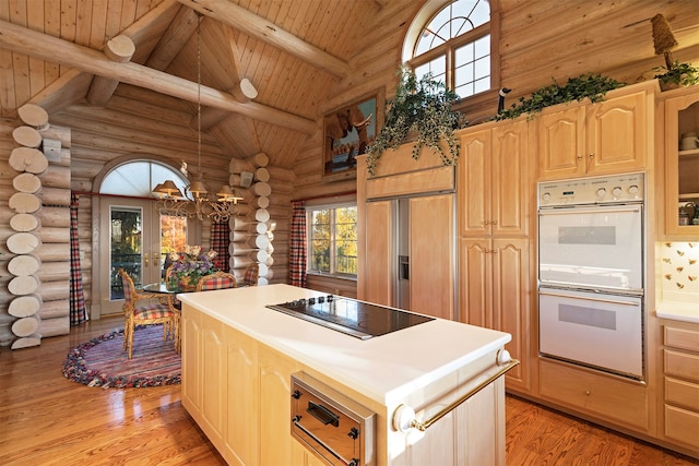 kitchen with a center island, rustic walls, black electric cooktop, double oven, and light hardwood / wood-style flooring