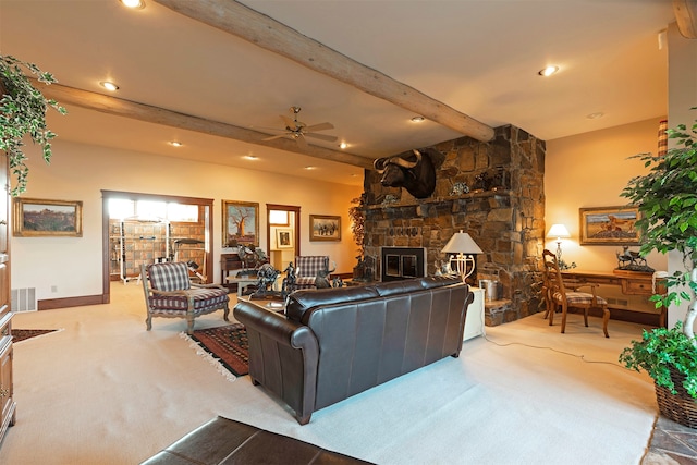 carpeted living room featuring a stone fireplace, ceiling fan, and beamed ceiling