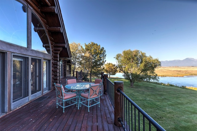 wooden terrace featuring a lawn and a mountain view