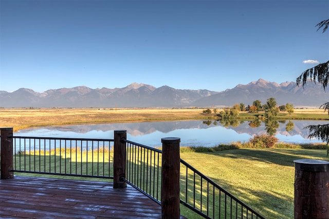 wooden terrace with a water and mountain view and a yard