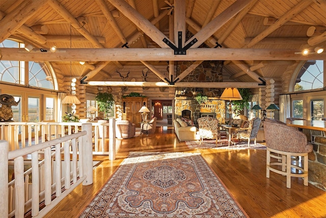 55263 Logan Rd, Charlo, MT 59824 - interior space featuring wooden ceiling with exposed beams, high vaulted ceiling, rustic walls, hardwood / wood-style floors, and plenty of natural light