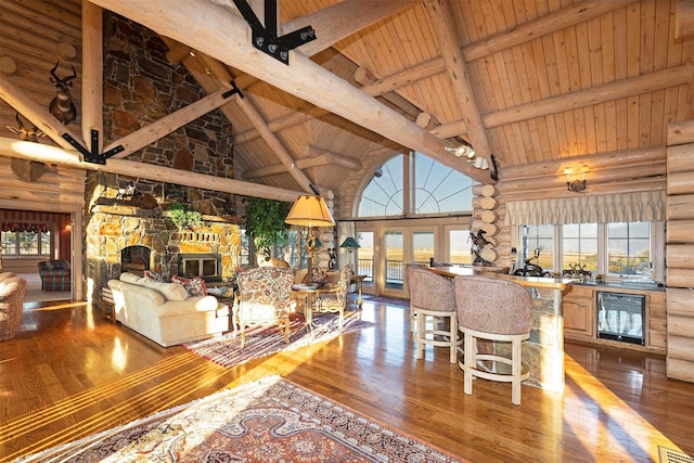 55263 Logan Rd, Charlo, MT 59824 - living area featuring log walls, high vaulted ceiling, wooden ceiling with exposed beams, hardwood / wood-style flooring, and wine cooler