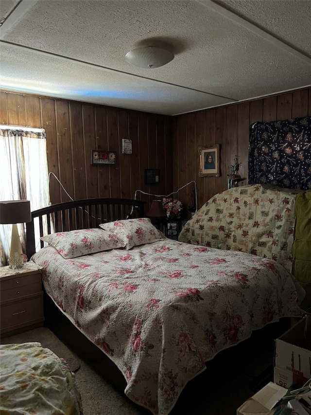 carpeted bedroom with wooden walls and a textured ceiling