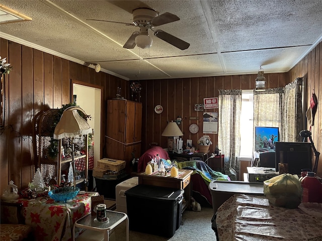 carpeted living room featuring ceiling fan and wood walls