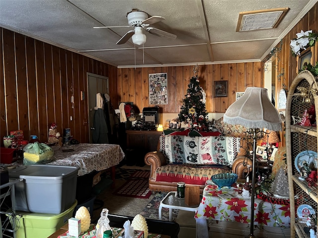 miscellaneous room featuring wood walls and ceiling fan