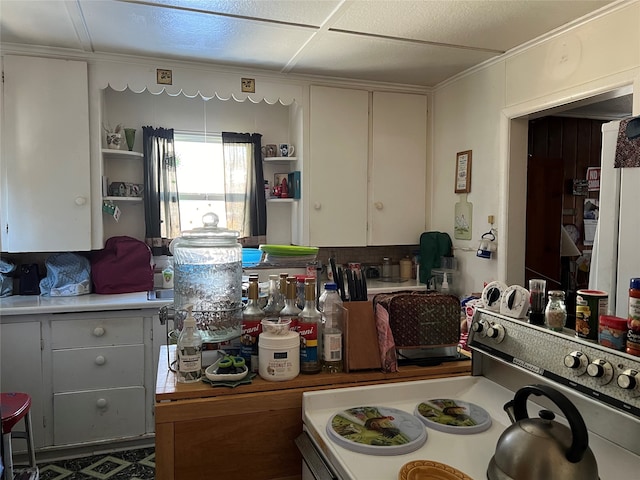 kitchen featuring white cabinets and range