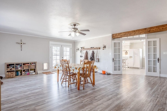 dining space featuring a textured ceiling, french doors, light hardwood / wood-style flooring, and ceiling fan