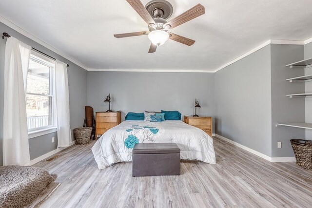 bedroom with crown molding, light hardwood / wood-style flooring, and ceiling fan