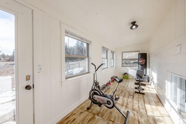 workout area with lofted ceiling and light wood-type flooring