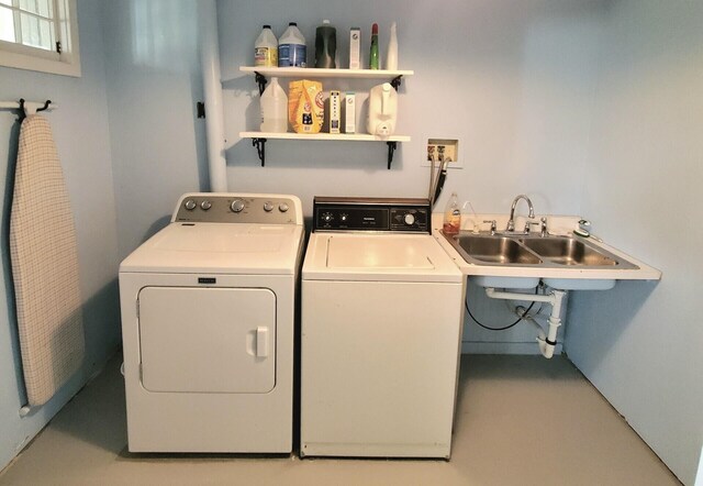 clothes washing area featuring washer and clothes dryer and sink