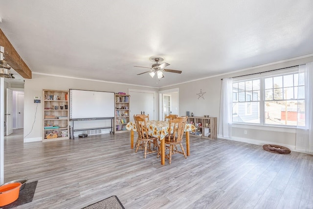 dining area featuring light hardwood / wood-style flooring, ornamental molding, and ceiling fan