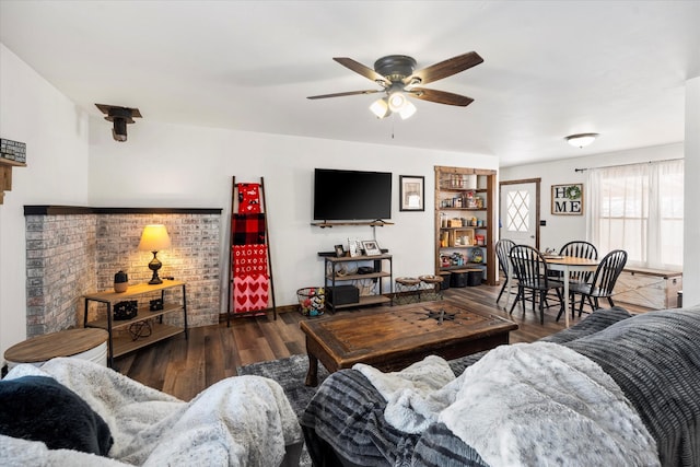 living room with ceiling fan and dark wood-type flooring