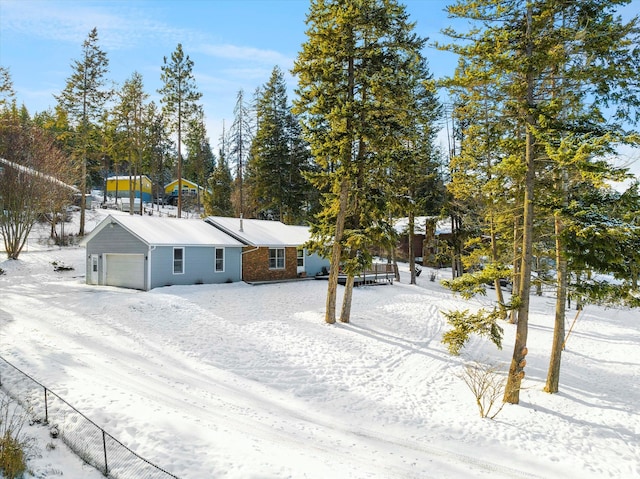 yard covered in snow featuring a garage