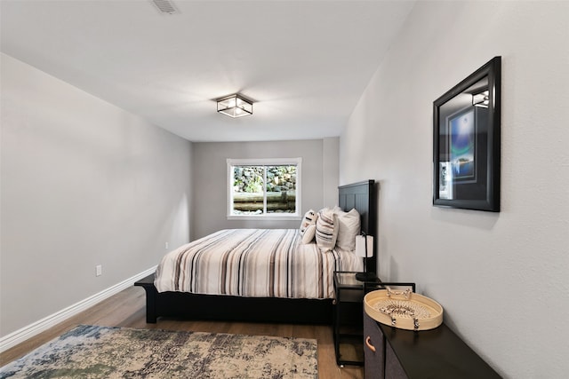 bedroom with dark hardwood / wood-style flooring