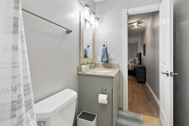 bathroom featuring oversized vanity, toilet, and wood-type flooring