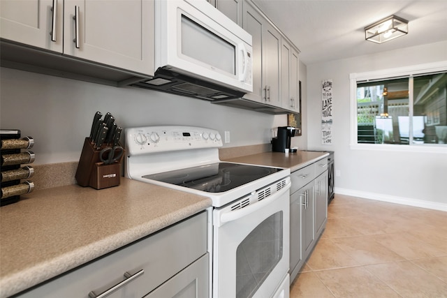 kitchen featuring white appliances, gray cabinetry, and light tile floors