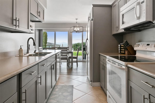 50300 US Highway 93 Unit B1/32, Polson, MT 59860 - kitchen with stainless steel appliances, gray cabinets, light countertops, hanging light fixtures, and light tile patterned floors