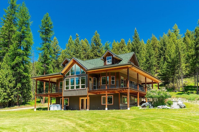 back of house with a lawn and a hot tub