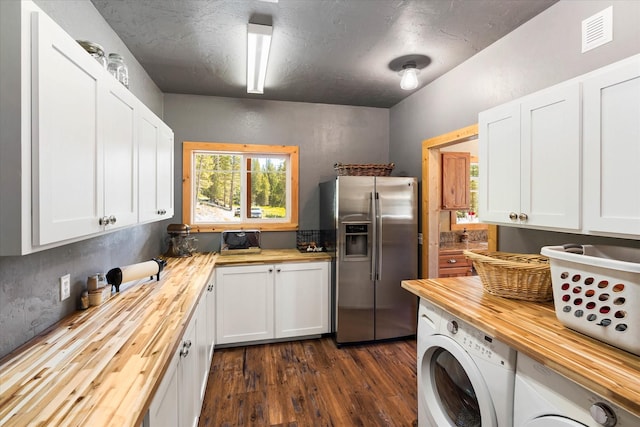 kitchen featuring stainless steel refrigerator with ice dispenser, butcher block countertops, and white cabinetry