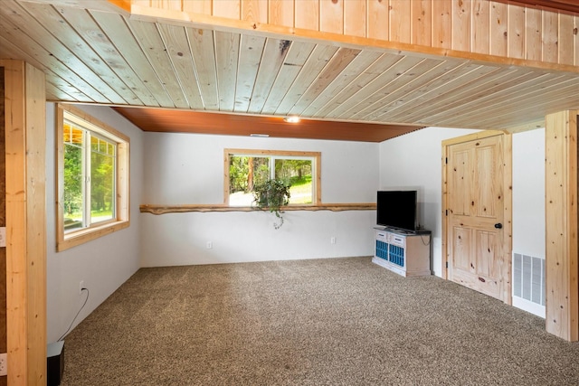 unfurnished living room with carpet flooring, plenty of natural light, and wooden ceiling