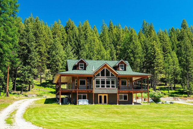 rear view of house featuring a lawn and cooling unit