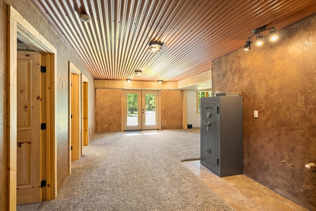 interior space featuring french doors, light colored carpet, and wood ceiling