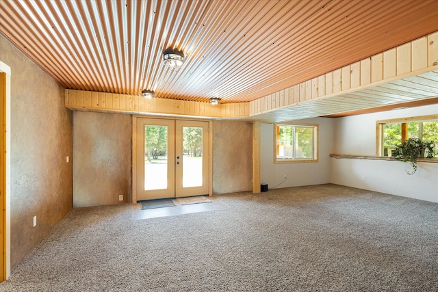 carpeted empty room with french doors and wooden ceiling