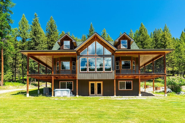 rear view of property featuring a lawn, french doors, a jacuzzi, and central AC