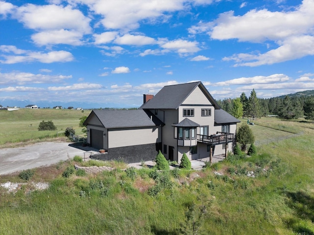 exterior space featuring a rural view, a garage, and a deck