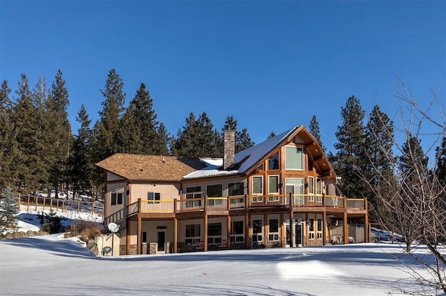 snow covered house with a wooden deck