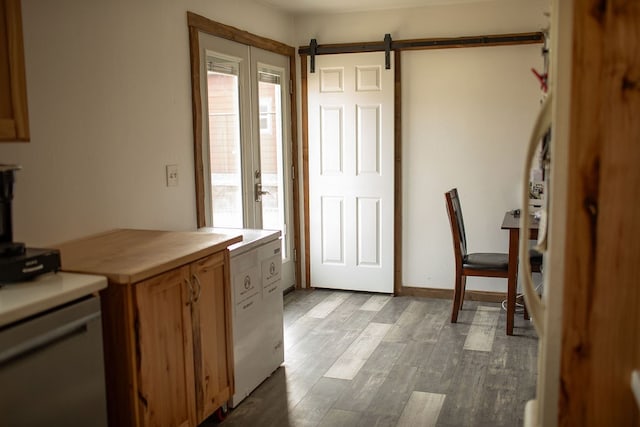 kitchen with a barn door and light wood-type flooring