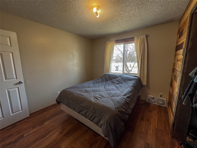 bedroom with a textured ceiling and dark wood-type flooring