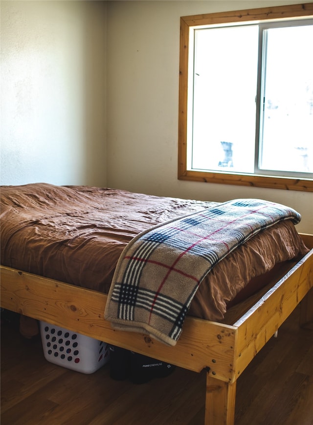 bedroom with dark wood-type flooring and multiple windows