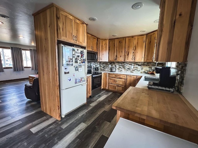 405 S Cherry St, Townsend, MT 59644 - kitchen featuring freestanding refrigerator, black microwave, electric stove, decorative backsplash, and brown cabinetry