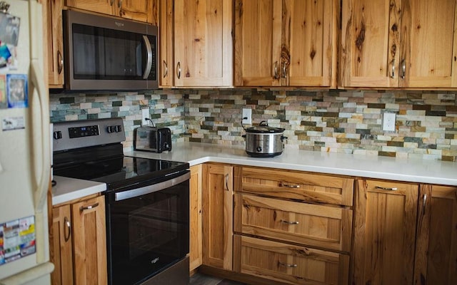 405 S Cherry St, Townsend, MT 59644 - kitchen featuring appliances with stainless steel finishes, decorative backsplash, light countertops, and brown cabinets
