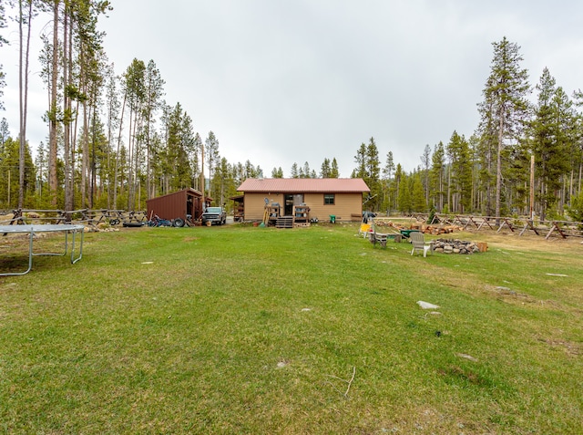 view of yard with an outdoor structure and a trampoline