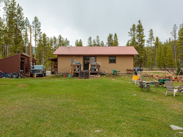 rear view of house featuring a storage shed and a yard