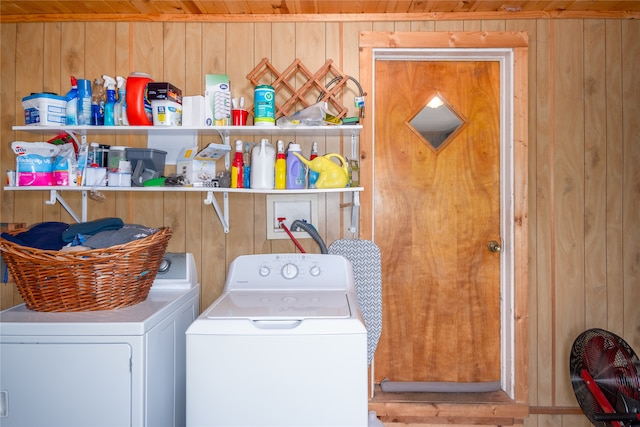 laundry room with hookup for a washing machine, wooden walls, and washing machine and clothes dryer